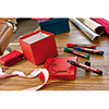 Liegende rote Geschenkbox mit Beschriftung, umgeben von verschiedenen Edding Permanentmarkern.
