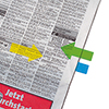 Transparente Haftstreifen in grüner und gelber Pfeilform markieren Textstelle in einer Zeitung.