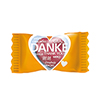 Orange Verpackung eines Bonbons in Herzform mit dem Schriftzug "DANKE" in mehreren Sprachen.