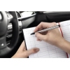 Hand, die in einem Fahrzeug ein Fahrtenbuch ausfüllt, im Hintergrund das Armaturenbrett sichtbar.