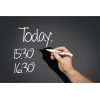 Schwarzes Glasboard zeigt handschriftliche Notizen und einen Marker in der rechten Hand.
