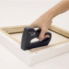 Handtacker wird verwendet, um eine Leinwand an einem Holzrahmen zu befestigen.