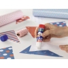 Klebestift wird verwendet, um Papierstücke auf einer bunten Bastelunterlage zu fixieren.