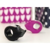 Farbig sortierte tesafilm® Mini Handabroller in Schwarz und Lila vor bunten Mustern.