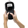 Person hält ein DYMO LabelManager 280 Beschriftungsgerät in den Händen und tippt auf der Tastatur.