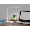 Weiße Tischleuchte mit flexiblem Arm neben einem Laptop und Pflanzen auf einem Tisch.