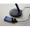 Tischleuchte mit taktilem Dimmer und integrierter Ladefunktion für ein Smartphone.