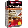 Kartonschachtel mit Kaffeesahne, rot, mit Deckel, Abbildung in einer Tasse Kaffee.