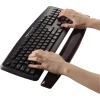 Schwarze Gel-Handgelenkauflage vor einer Tastatur mit zwei Händen, die darauf liegen.