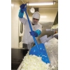 Ergonomische blaue Schaufel in Verwendung zum Heben von Lebensmitteln in einer Industrieumgebung.