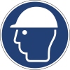 Rundes Hinweisschild mit einem weißen Helm-Icon auf blauem Hintergrund, symbolisiert Kopfschutz.