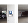 Folienetikett mit Parkplatzsymbol und Hinweis für Mitarbeiter an einer Wand in einer Tiefgarage.