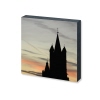 Dekobild in Form eines Fotoquadrats mit Silhouette einer Kirche vor pastellfarbenem Himmel.