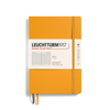 Gelbes Softcover-Notizbuch im DIN A5-Format mit eingelegtem Informationsblatt und Gummiband.