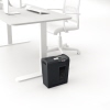 Aktenvernichter in Schwarz steht neben einem modernen Schreibtisch im Büro.