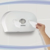 Toilettenpapierhalter mit einer Hand, die zwei Blätter des zentralen Toilettenpapiers entnimmt.