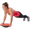 Eine Person führt eine Plank-Übung auf einem rot-schwarzen Balance Board aus.