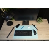 Zweifarbige Schreibunterlage auf einem Schreibtisch mit Monitor, Tastatur und Büromaterialien.