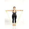 Frau demonstriert eine Übung mit einem gelben Fitnessband, das an den Füßen fixiert ist.