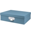 Aufbewahrungsbox in Denimblau mit Metallgriff, quadratischer Form und geschlossenem Design.