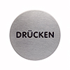 Rundes Türschild aus brushed Metall mit dem Wort "DRÜCKEN" in schwarzer Schrift.