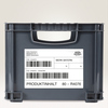 Graue Transportbox mit einem Folienetikett, beschriftet mit "WERK BAYERN" und Barcodes.