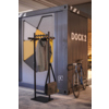 Stehende Garderobe mit Kleidungsstücken und Tasche, platziert vor farbiger Wand mit Fahrrad.