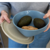 Koziol Vorratsdose in blau mit Avocados und Ingwer, gehalten von einer Person im Bild.