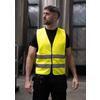 Signalgelbe Warnweste mit zwei reflektierenden Streifen, getragen von einem stehenden Mann.