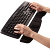 Schwarze Handgelenkauflage mit ergonomischem Design, platziert vor einer Computer-Tastatur.