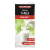Laktosefreie H-Milch in einer Verpackung mit Drehverschluss, die in ein Glas gegossen wird.