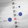 Ablösbare blaue Markierungspunkte auf einem Kalender zur Kennzeichnung von Terminen.