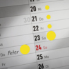 Gelbe Markierungspunkte auf einem Kalender zur Kennzeichnung von Terminen oder Hinweisen.