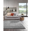 Grauer Teppich DOLCE auf einem Boden in einem modern eingerichteten Wohnzimmer.