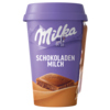 Lila Becher mit Schokoladenmilch-Logo und Kakaostück auf einem sandfarbenen Untergrund.