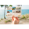 Kugelschreiber in Goldfarbe liegt auf einer Postkarte mit Urlaubsmotiven am Strand.