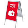 Rot-weißer Kundenstopper mit dem Schriftzug "ERSTE HILFE" und einem Symbol für erste Hilfe.