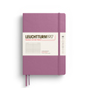 Liniert, rosa Hardcover-Notizbuch im Format DIN A5 mit Band und Etikett.