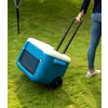 Wheeled Kühlbox in Blau mit ausziehbarem Griff, im Einsatz auf grünem Gras.
