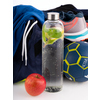 Transparente Trinkflasche mit Schraubverschluss, umgeben von Sportkleidung, einem Apfel und Bällen.
