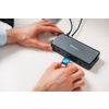 Dockingstation mit USB-Anschluss, benutzt an einem Arbeitsplatz mit Laptop und Zubehör.