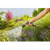 Person hält GARDENA Komfort Gartenbrause und sprüht Wasser auf blühende Pflanzen im Garten.