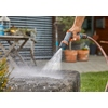 Gartenbrause wird verwendet, um einen Wasserstrahl auf eine Steinoberfläche zu richten.