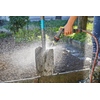 Gartenbrause wird zur Reinigung eines verschmutzten Objekts mit Sprühwasser eingesetzt.