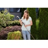 GARDENA Fugenkratzer im Einsatz zur Unkrautentfernung zwischen Pflanzen vor einer Hecke.