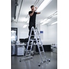 MUNK Multifunktionsleiter zeigt Nutzer beim Arbeiten auf der Leiter in einem modernen Raum.