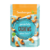 Geröstete Cashewkerne in einer Verpackung mit Holzuntergrund, ohne sichtbare Gewürze oder Salz.