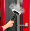 Handdampfreiniger reinigt eine rote Tür mit Dampfausstoß aus einer Düse.