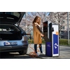 Frau lädt Elektroauto mit orangefarbenem LAPP Ladekabel an einem öffentlichen Ladegerät.