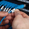 Ein Mensch bringt ein etikettiertes Kabel in einem Kabelmanagement-System an.
